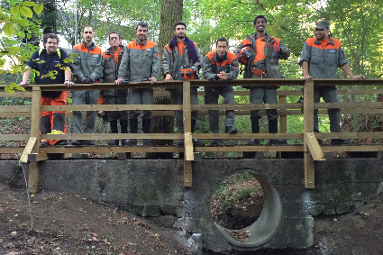 Des astreints pose sur la passerelle qu'ils viennent de rénover